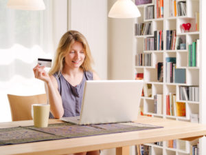 Photo of a beautiful young female shopping online and paying with a credit card. Credit card information is fictitious.